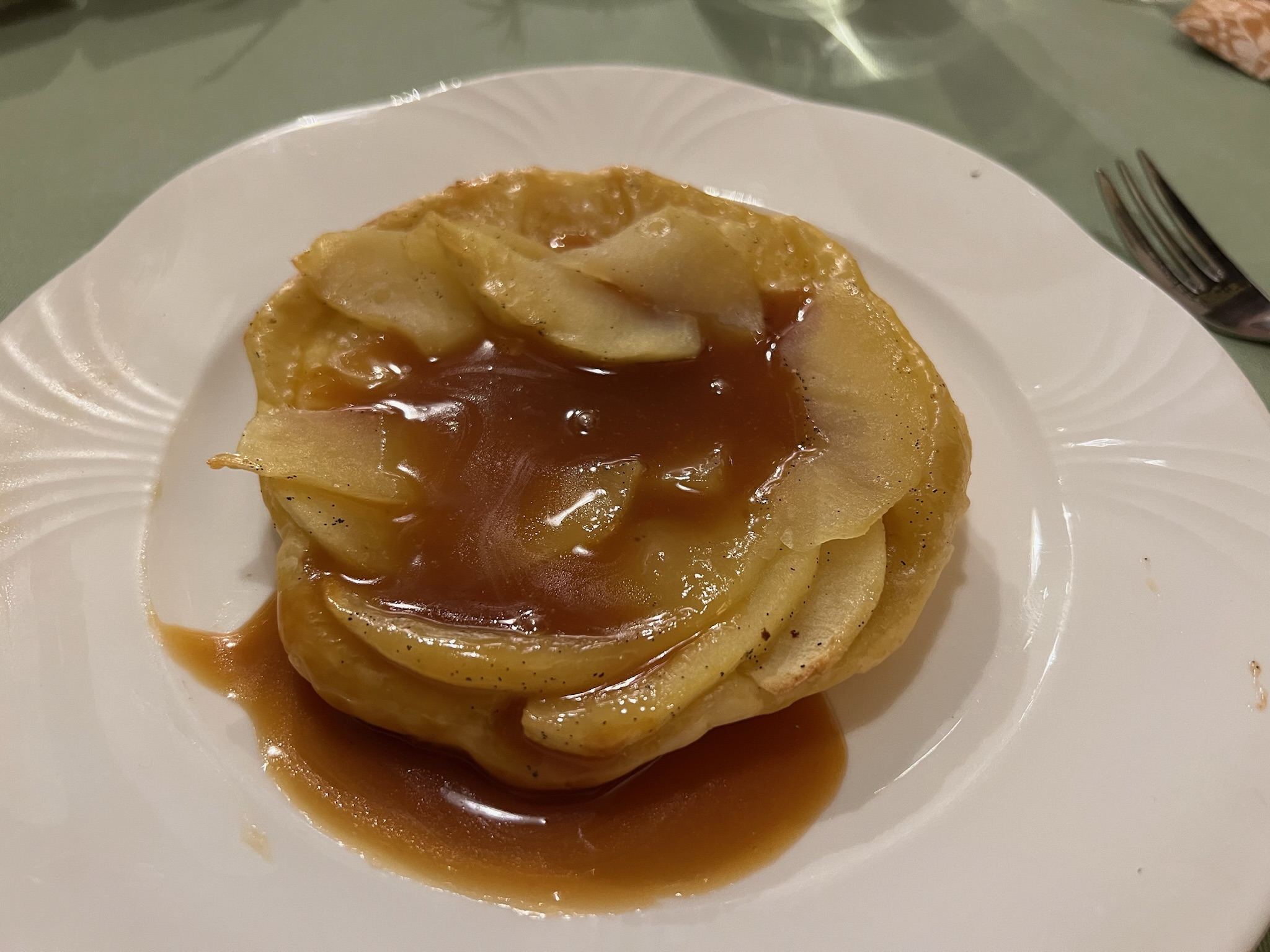Kleine tarte tatin met karamelappel en knapperig bladerdeeg op een wit bord